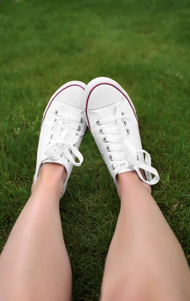 Kvinnan fötter i sneakers — Stockfoto