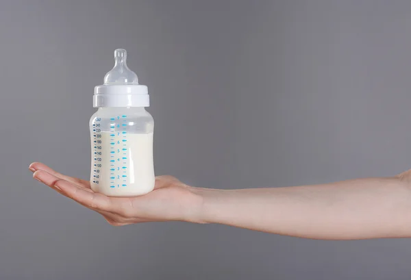 Hand holding baby bottle — Stock Photo, Image