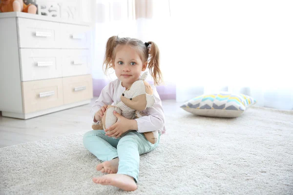 Kleine schattige meisje met teddybeer thuis — Stockfoto