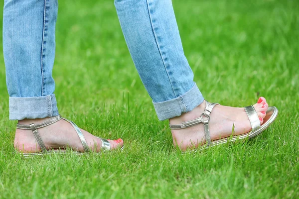 Vrouwelijke voeten in sandalen — Stockfoto