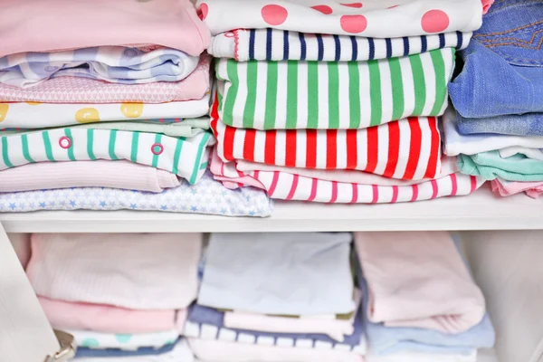 Kleding voor kinderen op de planken — Stockfoto