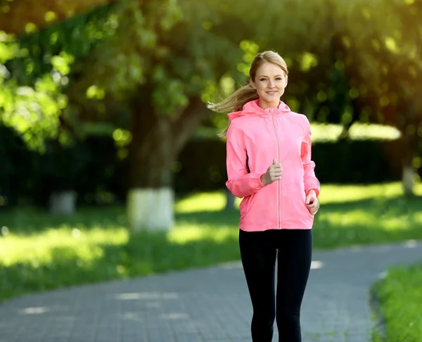Femme sportive jogging au parc par une journée ensoleillée — Photo