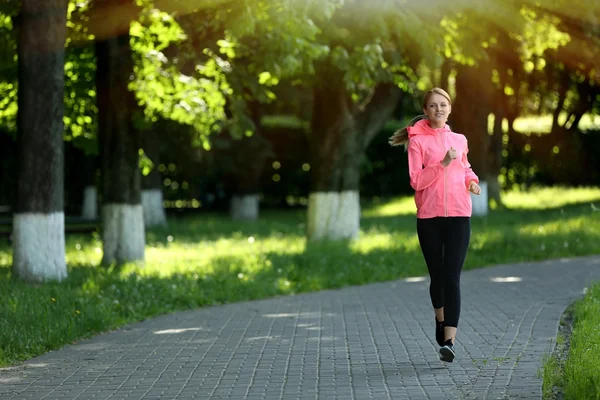 Femme sportive jogging au parc par une journée ensoleillée — Photo