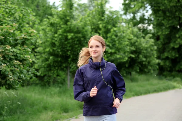 Femme sportive jogging au parc par une journée ensoleillée — Photo