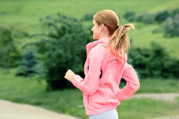 Femme sportive jogging au parc par une journée ensoleillée — Photo