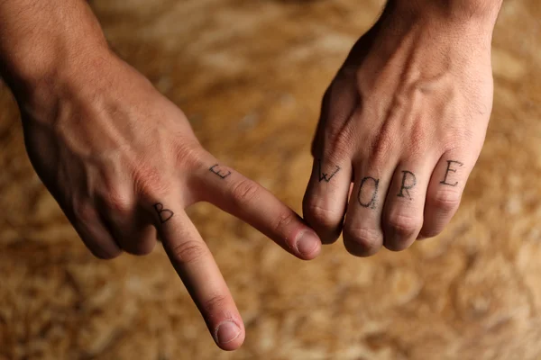 Tattoo inscriptions on male fingers