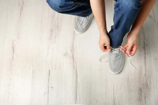 Чоловік зав'язує взуття мереживами — стокове фото