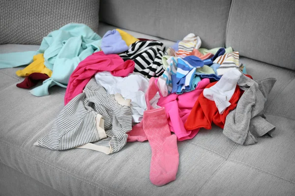 Хаос одежды на диване — стоковое фото
