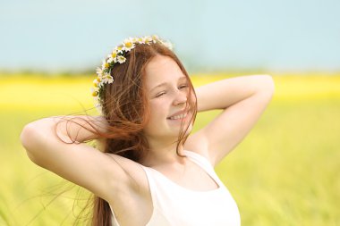 Tatlı kız vahşi bahar çiçekleri ile çayırda