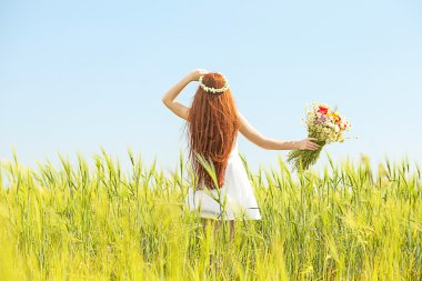 Tatlı kız vahşi bahar çiçekleri ile çayırda