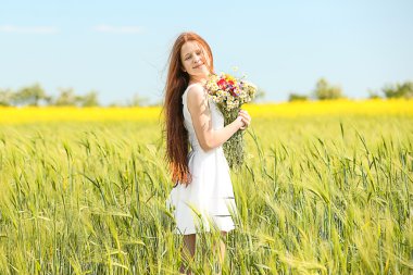 Tatlı kız vahşi bahar çiçekleri ile çayırda