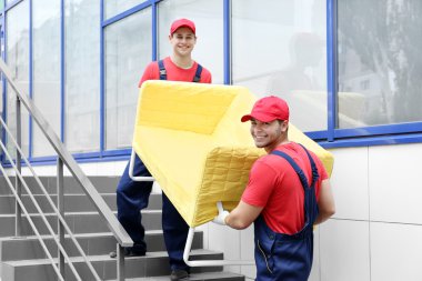 Merdivenler sarı koltukta ile iki erkek işçiler