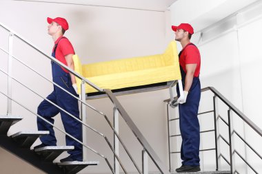 Merdivenler sarı koltukta ile iki erkek işçiler