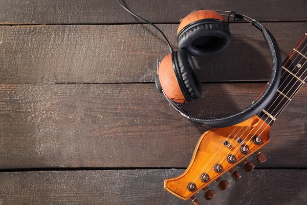 Guitar and headphones on wood — Stock Photo, Image