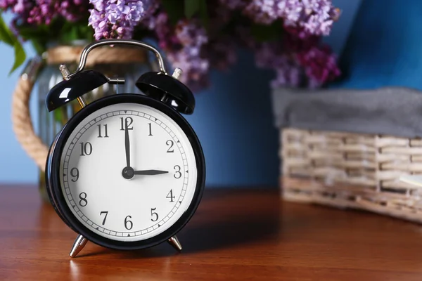Relógio despertador com buquê lilás — Fotografia de Stock
