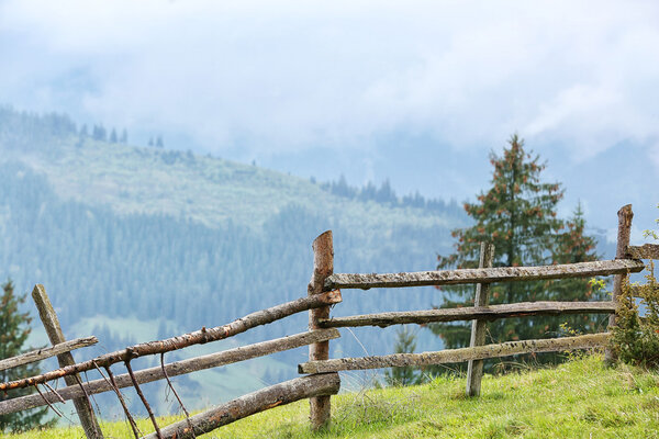 Деревянный забор на зеленом холме
