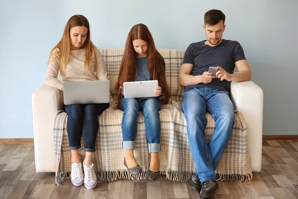 Concept de problèmes familiaux. Père, mère et fille assis sur le canapé avec des gadgets — Photo