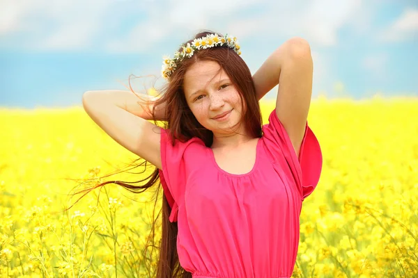Tatlı kız vahşi bahar çiçekleri ile çayırda — Stok fotoğraf