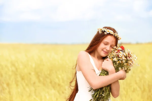 Portret van het meisje in weiland met wilde lente bloemen boeket — Stockfoto