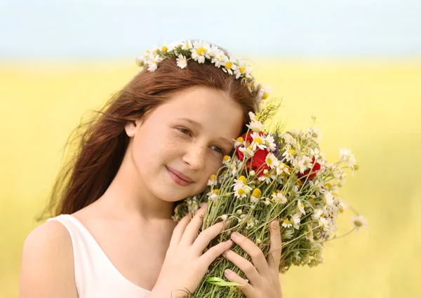 Portret van het meisje in weiland met wilde lente bloemen boeket — Stockfoto