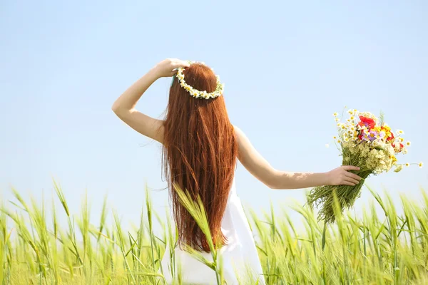 Sweet girl in meadow with wild spring flowers — Stock Photo, Image