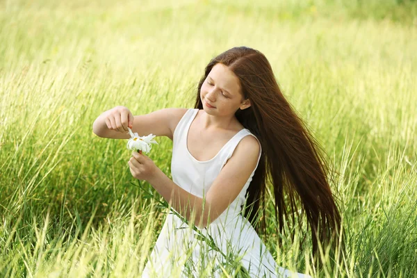 Menina doce no prado com flores de camomila — Fotografia de Stock