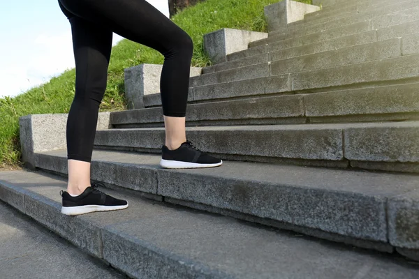 Woman running up on stone stairs — Stock Photo, Image