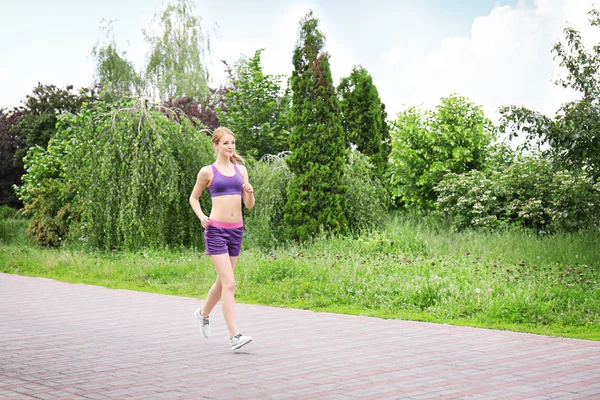 Sportif kadın güneşli bir günde Park'ta jogging