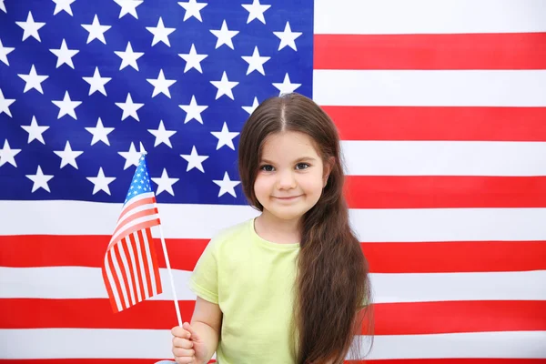 Linda niña en el fondo de la bandera americana — Foto de Stock