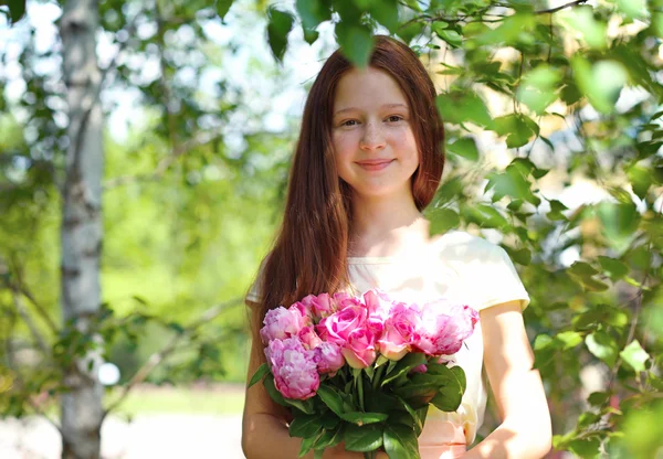 庭の新鮮な花束で美しい少女 — ストック写真