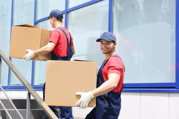 Two male workers with boxes on staircases — Stock Photo, Image