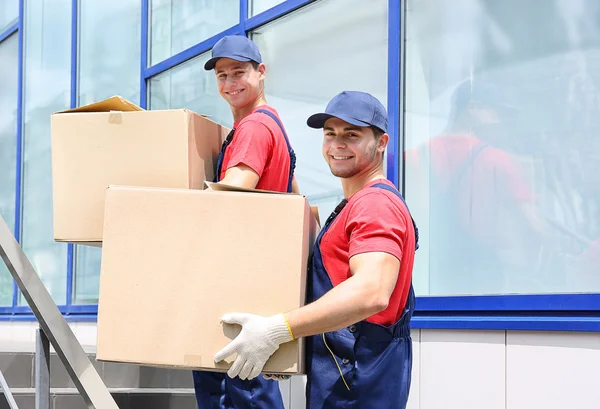 Dos trabajadores masculinos con cajas en escaleras — Foto de Stock