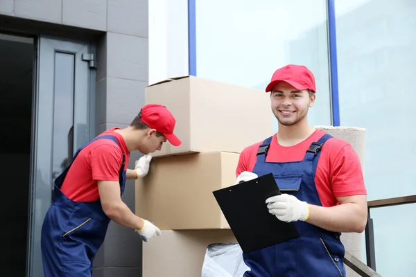 Dois trabalhadores do sexo masculino com caixas pesadas — Fotografia de Stock