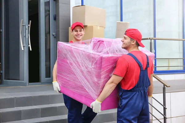 Dois trabalhadores do sexo masculino com poltrona rosa — Fotografia de Stock