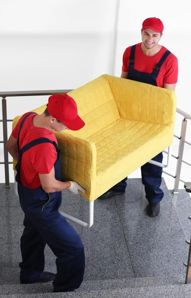 Mannelijke werknemers met luie stoel op trappen — Stockfoto