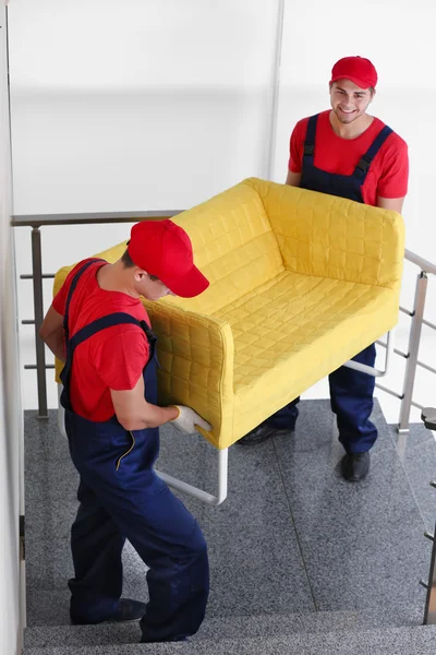 Deux travailleurs masculins avec canapé jaune sur les escaliers — Photo
