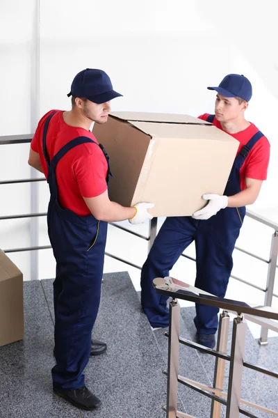 Dos trabajadores masculinos con caja en escaleras — Foto de Stock