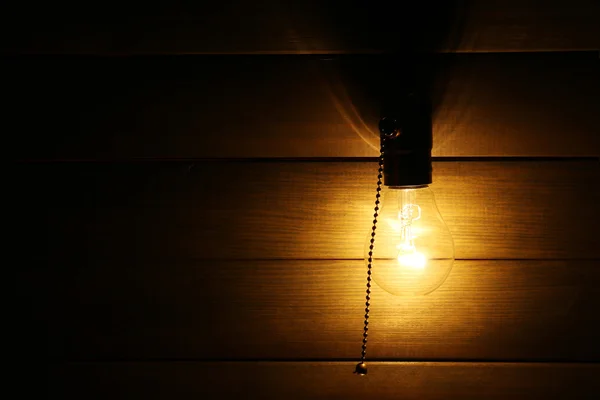 Light bulb on wooden background — Stock Photo, Image