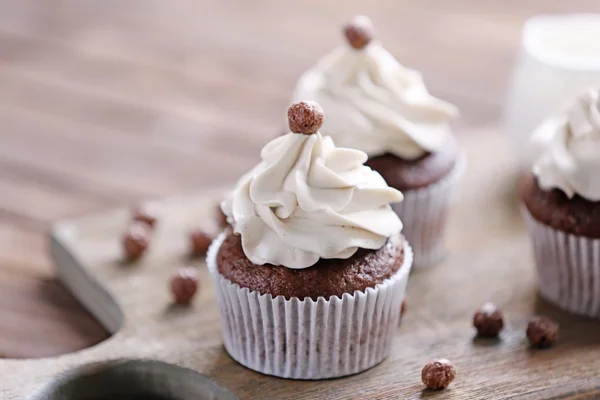 Smakelijke cupcakes op snijplank — Stockfoto