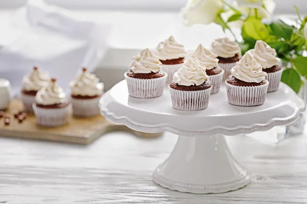 Cupcakes saborosos em stand branco — Fotografia de Stock