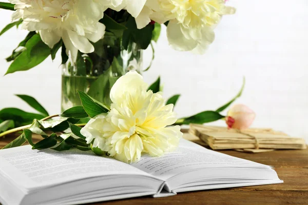 Beautiful peony flowers and open book — Stock Photo, Image