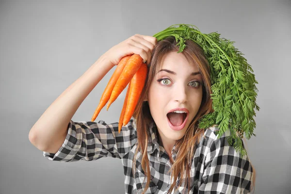 Menina bonita com cenouras frescas — Fotografia de Stock