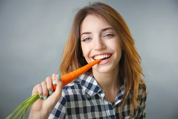 Menina bonita comer cenoura — Fotografia de Stock