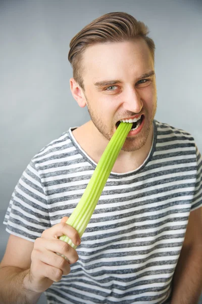 Schöner Mann isst Sellerie — Stockfoto