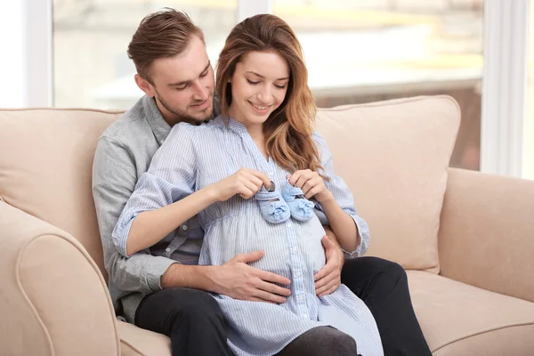 Pregnant woman holding baby shoes — Stock Photo, Image