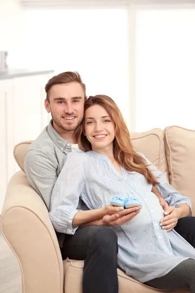 Pregnant woman holding baby shoes — Stock Photo, Image