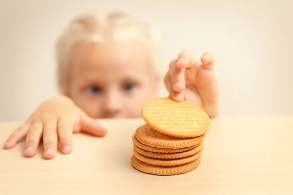 Menina engraçada olhando pilha de biscoitos — Fotografia de Stock