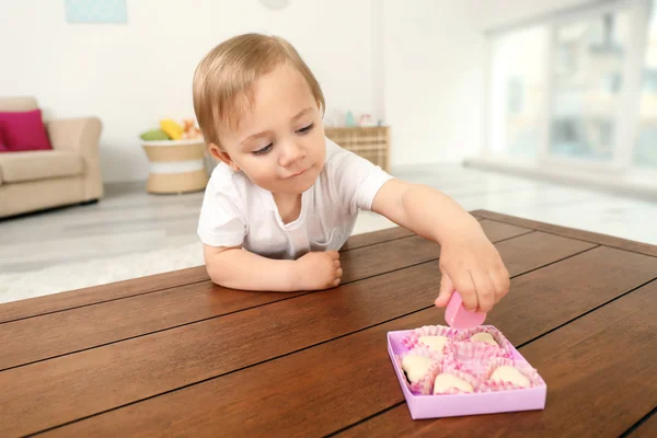 Bonito bebê menina tomando chocolate doce — Fotografia de Stock