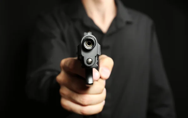 Man with gun on black — Stock Photo, Image