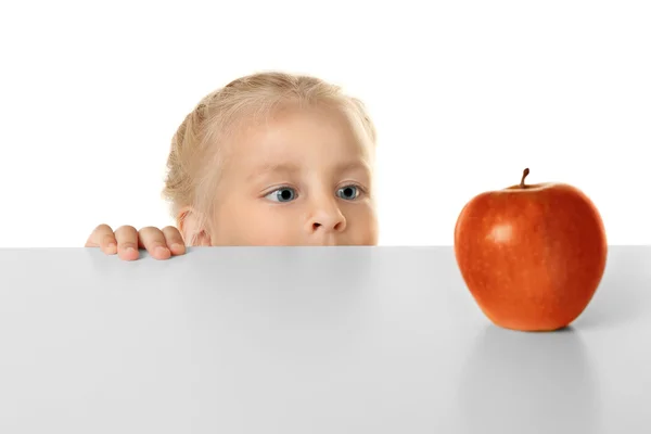 Lustiges kleines Mädchen beim Anblick von Apfel — Stockfoto